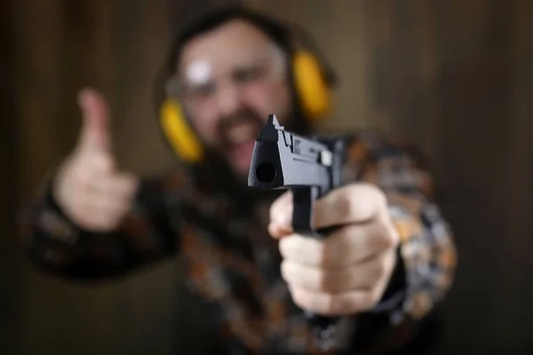 投入的护目镜和听觉训练在手枪 sh 的男人 — 图库照片