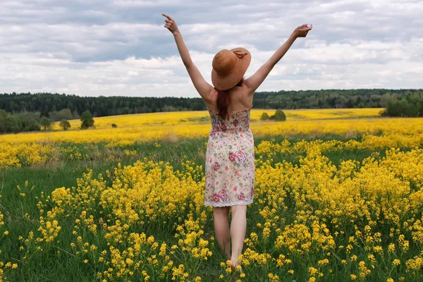 Девушка в поле цветов с корзиной и шляпой — стоковое фото