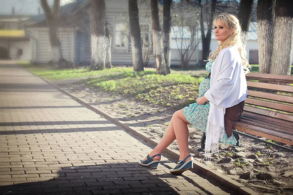 Chica embarazada caminando por el parque de la ciudad a principios de primavera — Foto de Stock