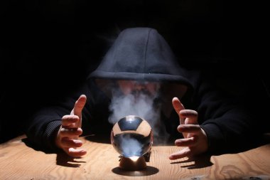 adam siyah başlıklı cristal topu ile