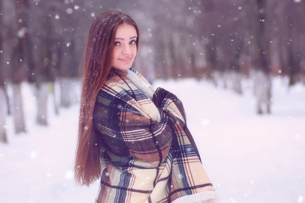 Linda chica con ojos azules envuelta en una manta en el invierno —  Fotos de Stock
