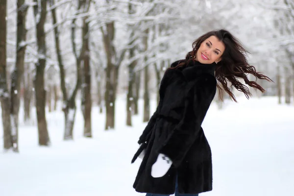 Женщина гуляет в зимнем заснеженном парке — стоковое фото
