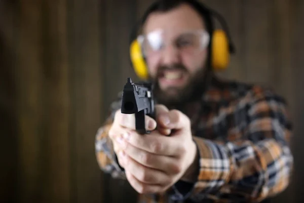 Hombre con gafas protectoras y entrenamiento de orejas en pistola sh —  Fotos de Stock