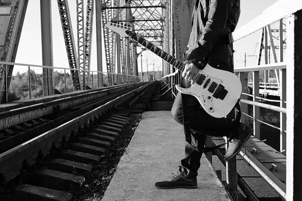 Monochroom man met een elektrische gitaar in de industriële landsca — Stockfoto