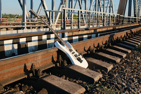 Witte elektrische gitaar op de railroad tracks en stenen — Stockfoto