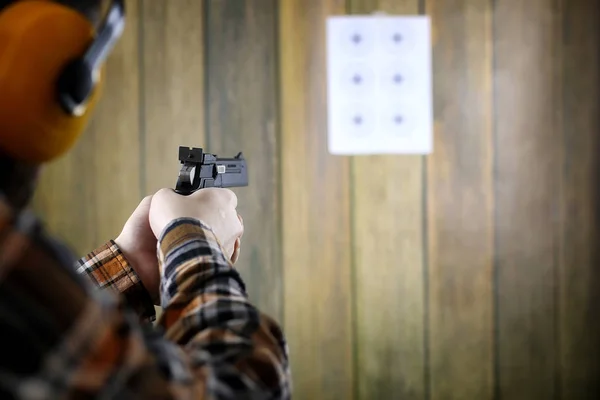 Hombre con gafas protectoras y entrenamiento de orejas en pistola sh —  Fotos de Stock