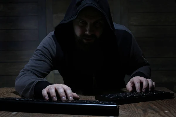 Hacker bir odaya ahşap duvarlar siyah başlıklı — Stok fotoğraf