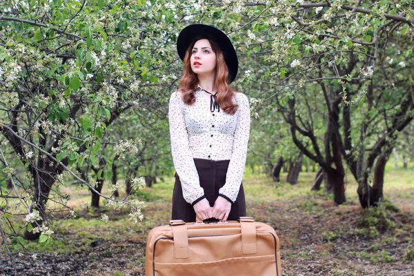Žena v parku venkovní kufr retro šaty — Stock fotografie