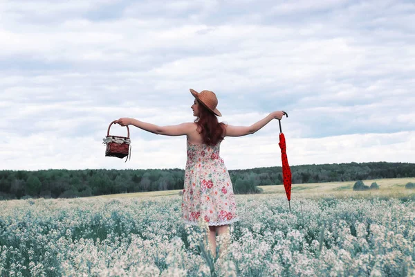 Chica en un prado de verano con flor blanca — Foto de Stock