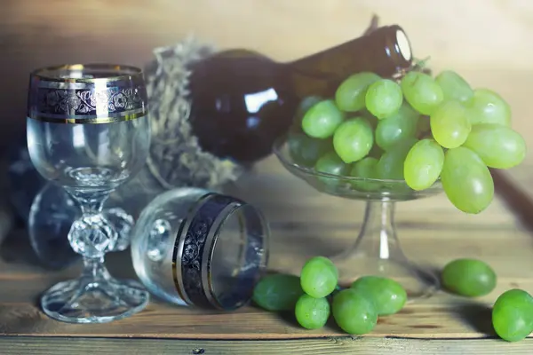 ボトルのワイン本とブドウの木のテーブル — ストック写真