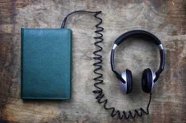 audiobook kulaklık ve ahşap masa kitap