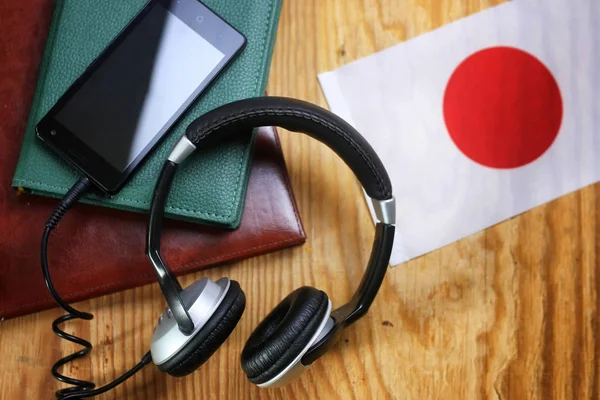 Auriculares y bandera sobre fondo de madera —  Fotos de Stock