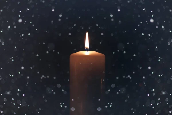 Černá svíčka světle izolované se sněhem — Stock fotografie