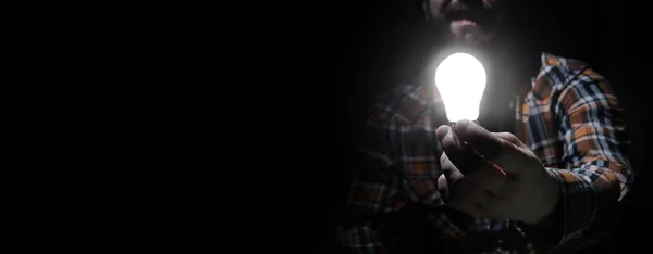 Man in dark with glow bulb — Stock Photo, Image