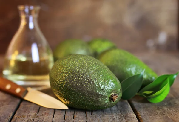 Aguacate y aceite sobre fondo de madera —  Fotos de Stock