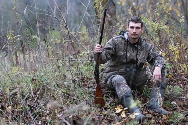 Kamuflaj ve bahar hun üzerinde orman Kuşağı'nda silahlı adam