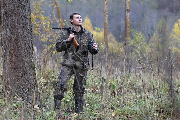 Hombre en camuflaje y con armas en un cinturón forestal en un hun de primavera —  Fotos de Stock