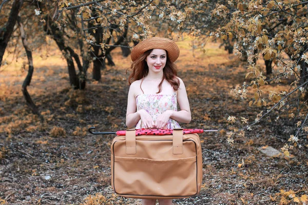 Niña con maleta de cuero para viajar en el parque de otoño a pie — Foto de Stock