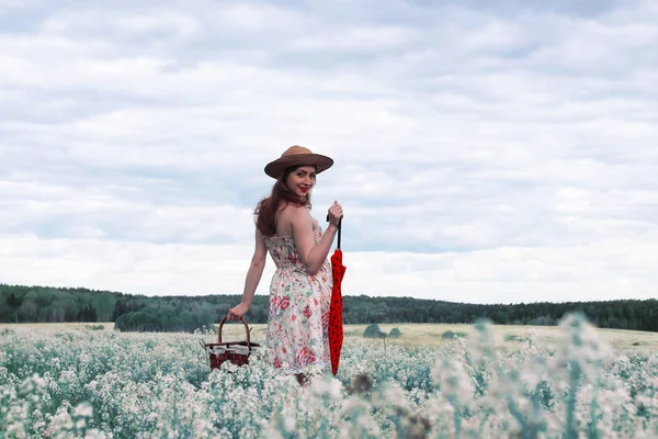 Meisje in een weide van de zomer met witte bloem — Stockfoto