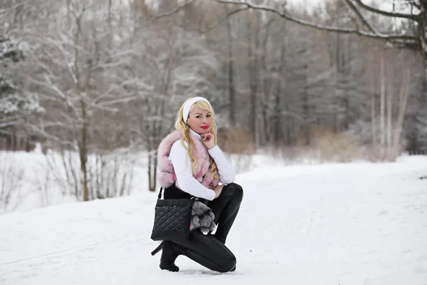 Blonde girl on a walk in a winter park — Stock Photo, Image