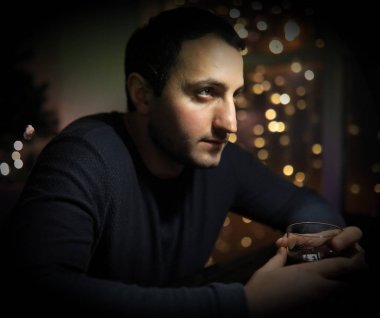 Barda bir bardak viskisi olan bir adam.