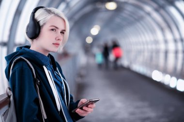 Genç öğrenci metro büyük kulaklıklar müzik dinlemek