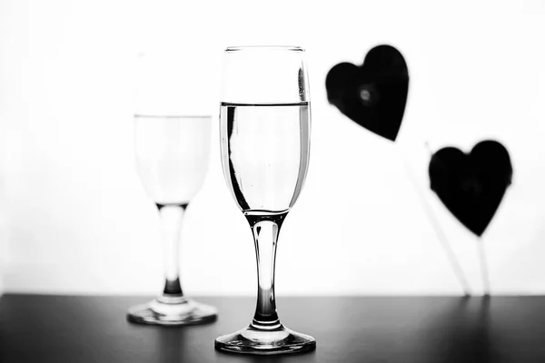 白い背景の白いテーブルの上のシャンパンのモノクロ写真 — ストック写真