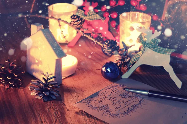 Yeni yıl el yazmak çam koni mum ile masada — Stok fotoğraf