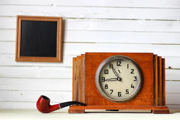 Old clock and smoking pipe — Stock Photo, Image