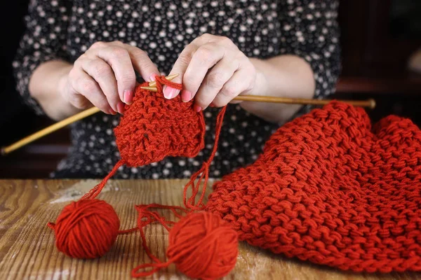 Літня жінка займається в'язанням теплих светрів для своєї великої — стокове фото
