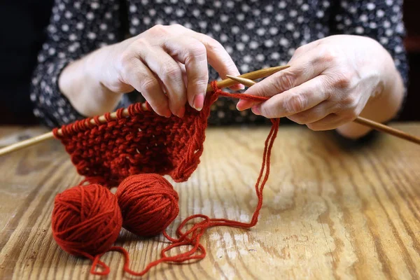 Starší žena se zabývá pletení teplé svetry pro její grand — Stock fotografie