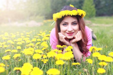 Sarı dandelions çayırda güneşli bir dinlenme kız