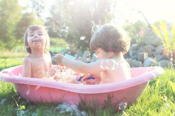 お風呂の水を屋外で子供たち — ストック写真