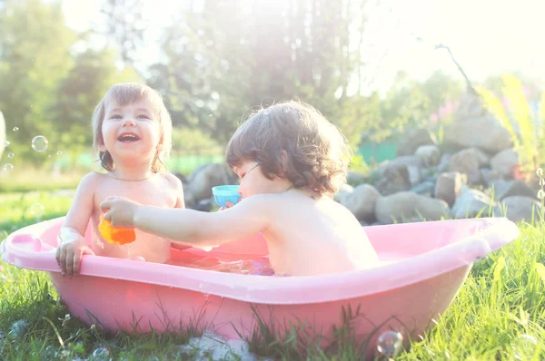 お風呂の水を屋外で子供たち — ストック写真