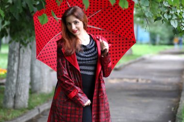 kadın bir yağmurluk ve şemsiye