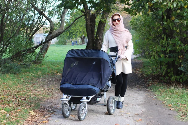 Girl in the park with stroller — Stock Photo, Image