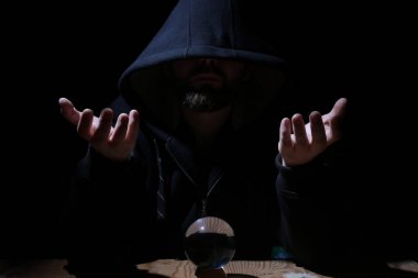adam siyah başlıklı cristal topu ile