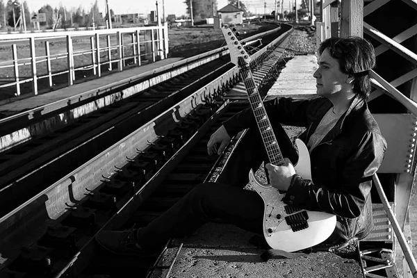 Homem monocromático com uma guitarra elétrica na landsca industrial — Fotografia de Stock