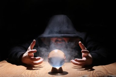 adam siyah başlıklı cristal topu ile