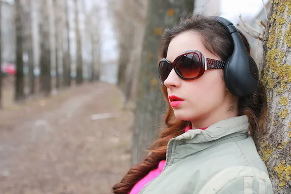 Sonbaharda parkta kulaklıklı bir kadın.