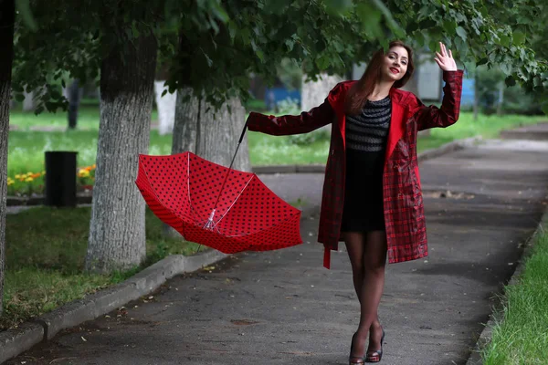 Žena v pláštěnku a deštník — Stock fotografie
