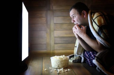 genç adam yerde evde televizyon izlerken