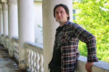 Adam terk edilmiş merdivenlerde oturuyor.