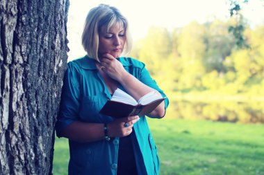 kadın yatıyordu ve kitap Güneş okuyun