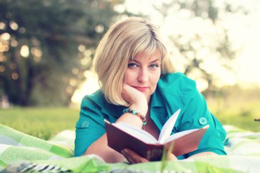 kadın yatıyordu ve kitap Güneş okuyun