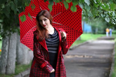 kadın bir yağmurluk ve şemsiye