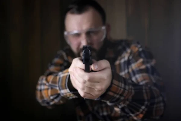 Hombre con gafas protectoras y entrenamiento de orejas en pistola sh —  Fotos de Stock