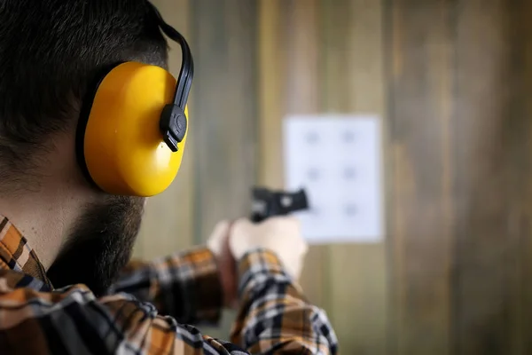 Muž se dal na ochranné brýle a ucho školení v pistoli sh — Stock fotografie
