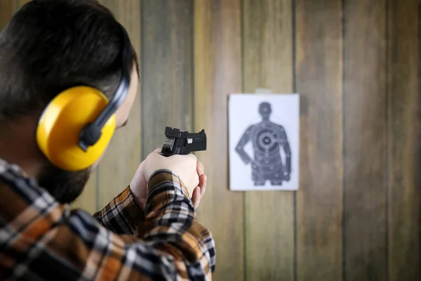 Muž se dal na ochranné brýle a ucho školení v pistoli sh — Stock fotografie