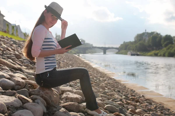 Chica al aire libre leer libro piedra río —  Fotos de Stock